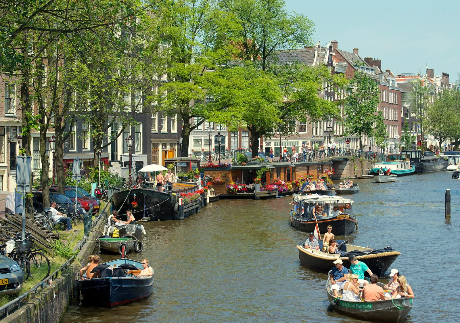 Canal del Jordaan con casas flotantes y barcas en verano
