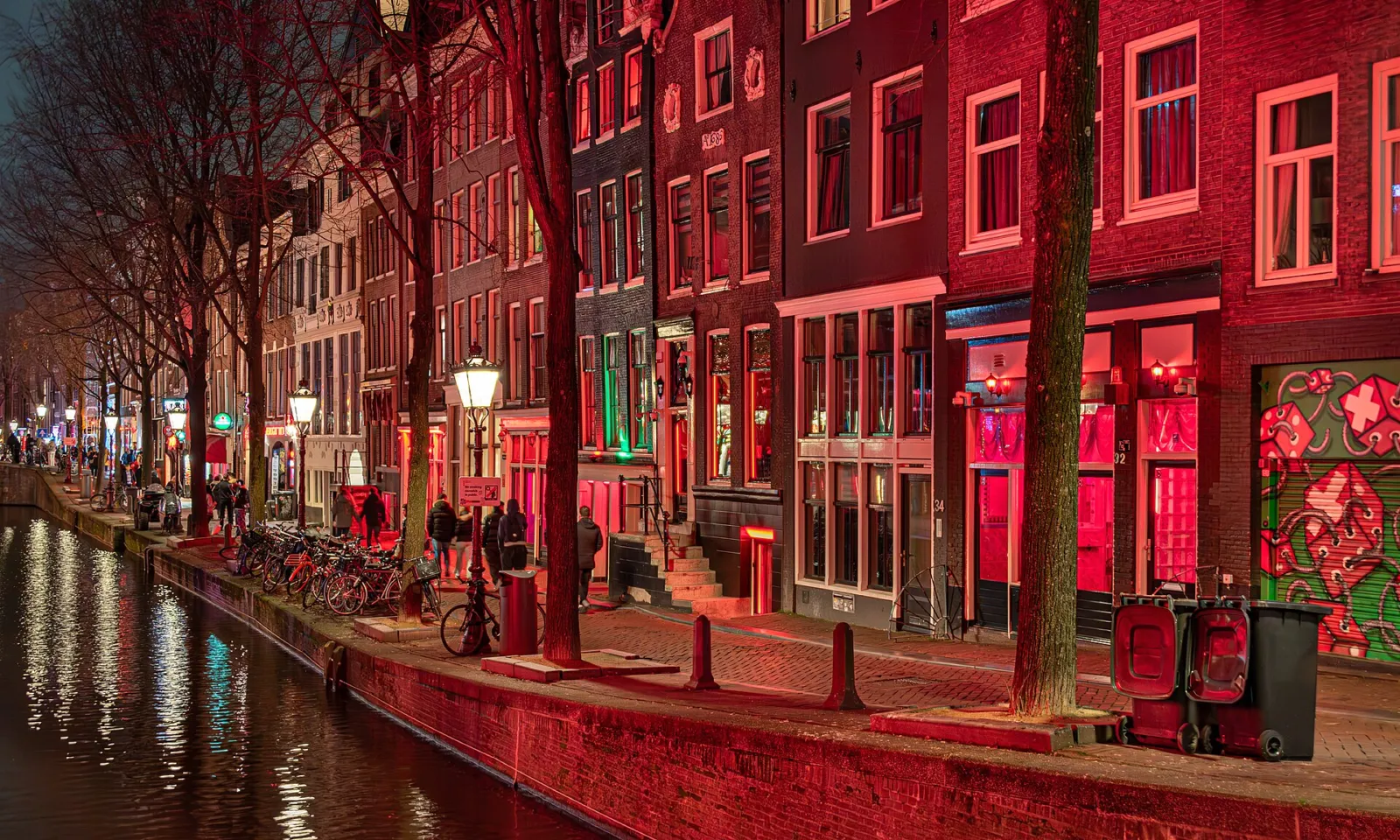 Fachadas iluminadas de rojo junto al canal del Barrio Rojo de noche