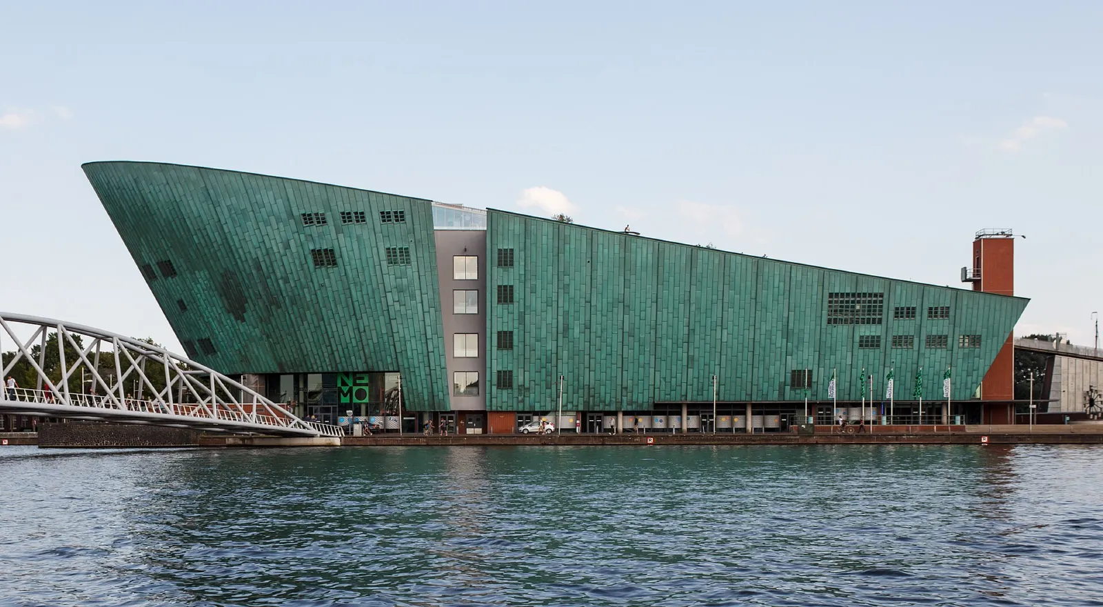 Edificio verde con forma de barco del museo de la ciencia NEMO visto desde el agua