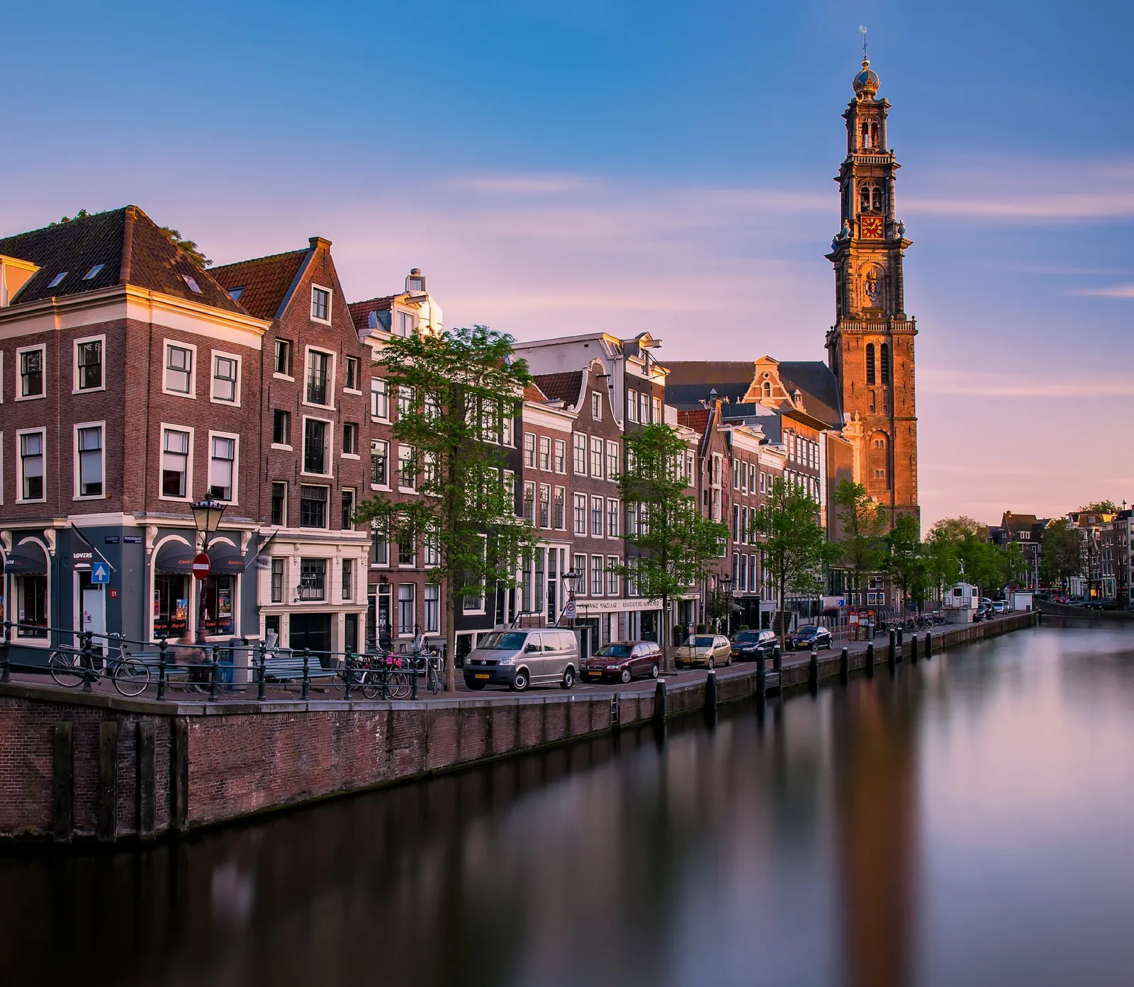 Torre de la Westerkerk sobre el canal Prinsengracht al atardecer
