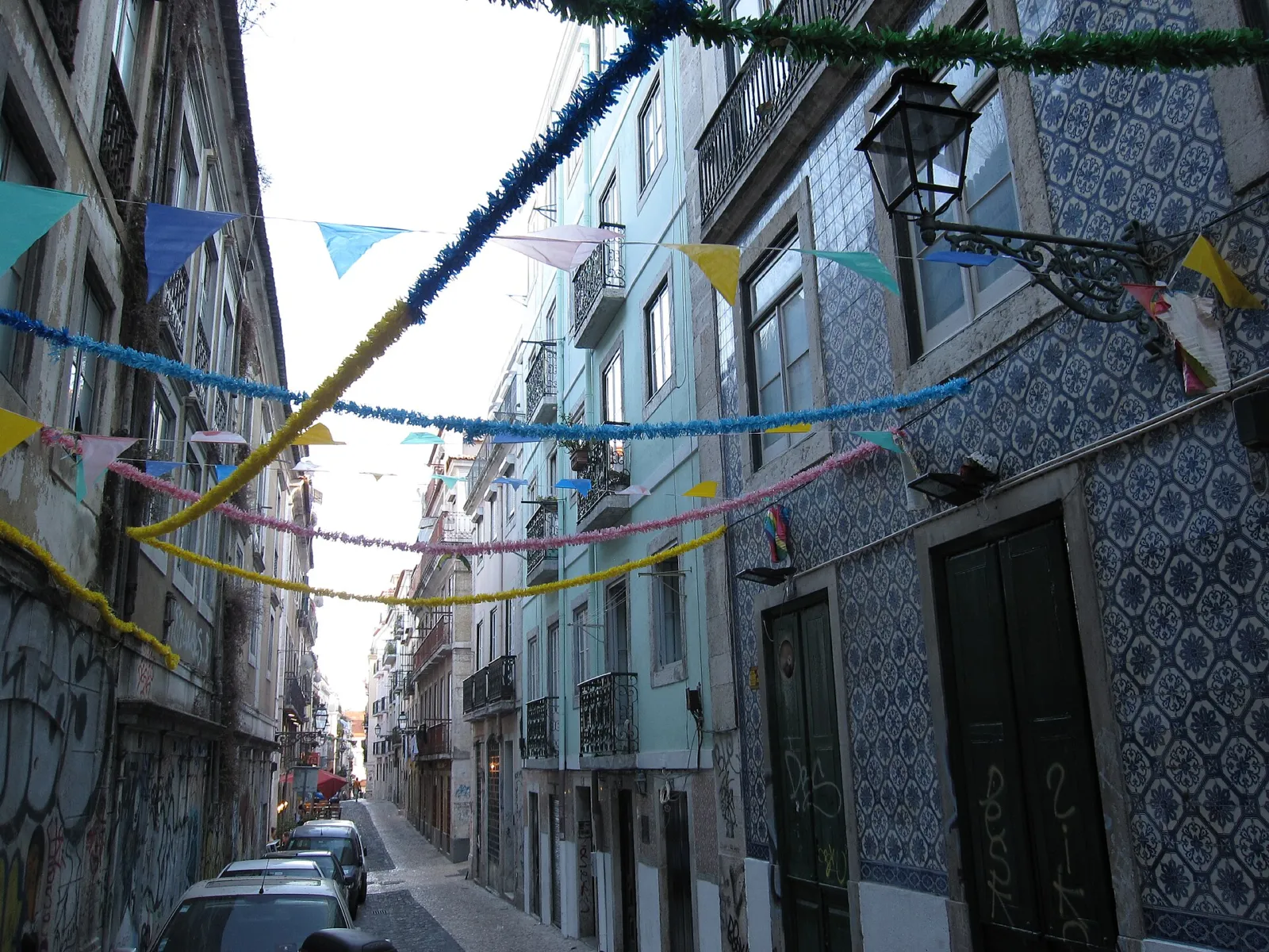 Calle del Bairro Alto de Lisboa decorada con banderines y fachadas de azulejos