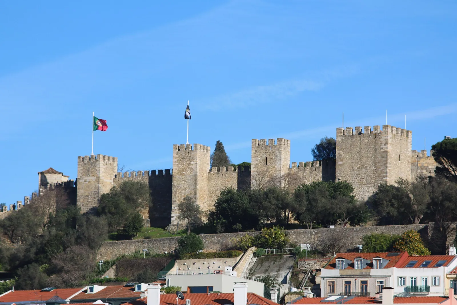 Murallas y torres del Castillo de San Jorge sobre la colina de Lisboa con la bandera ondeando