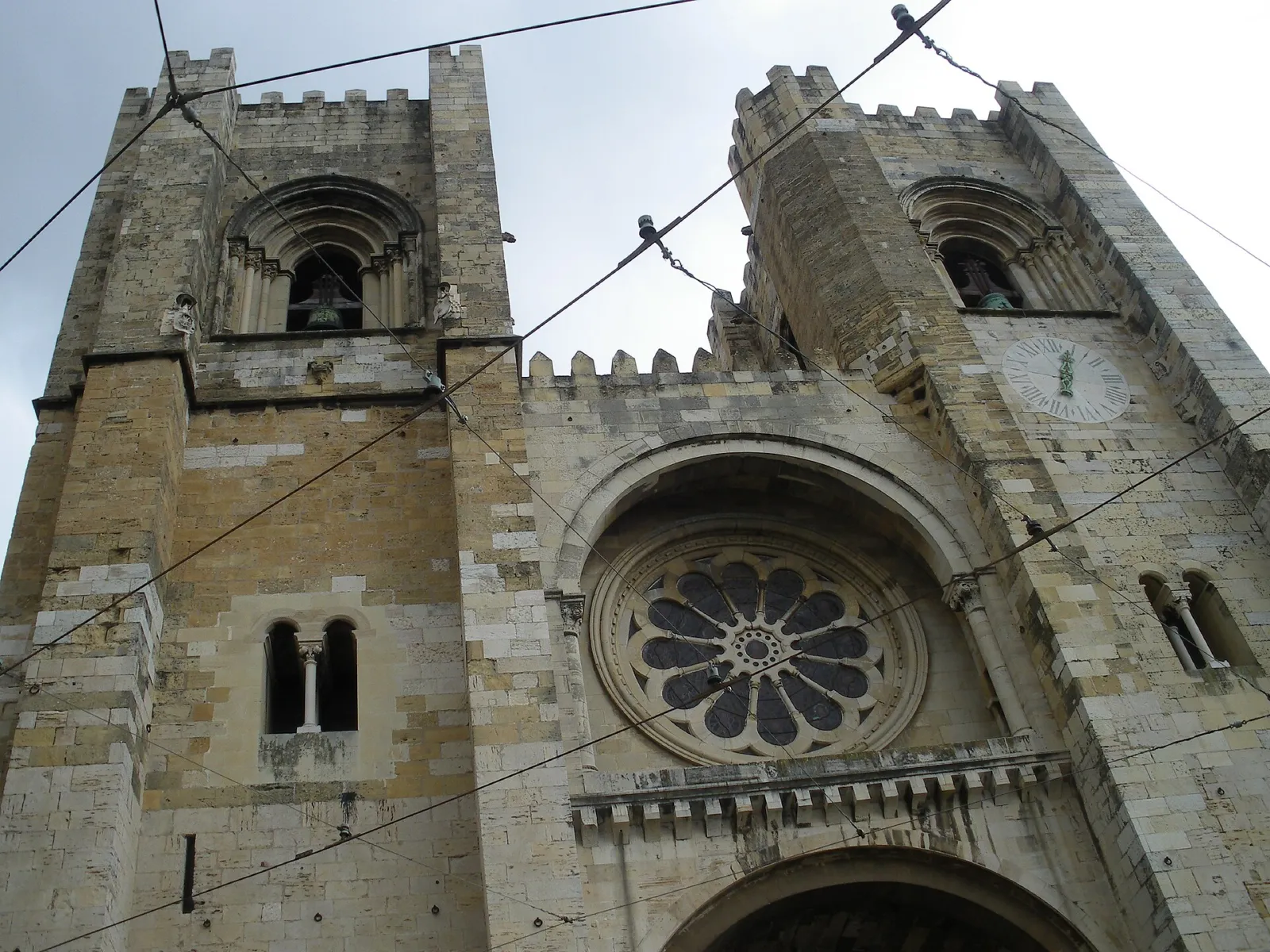 Fachada románica de la Catedral de Lisboa con sus dos torres almenadas y el rosetón
