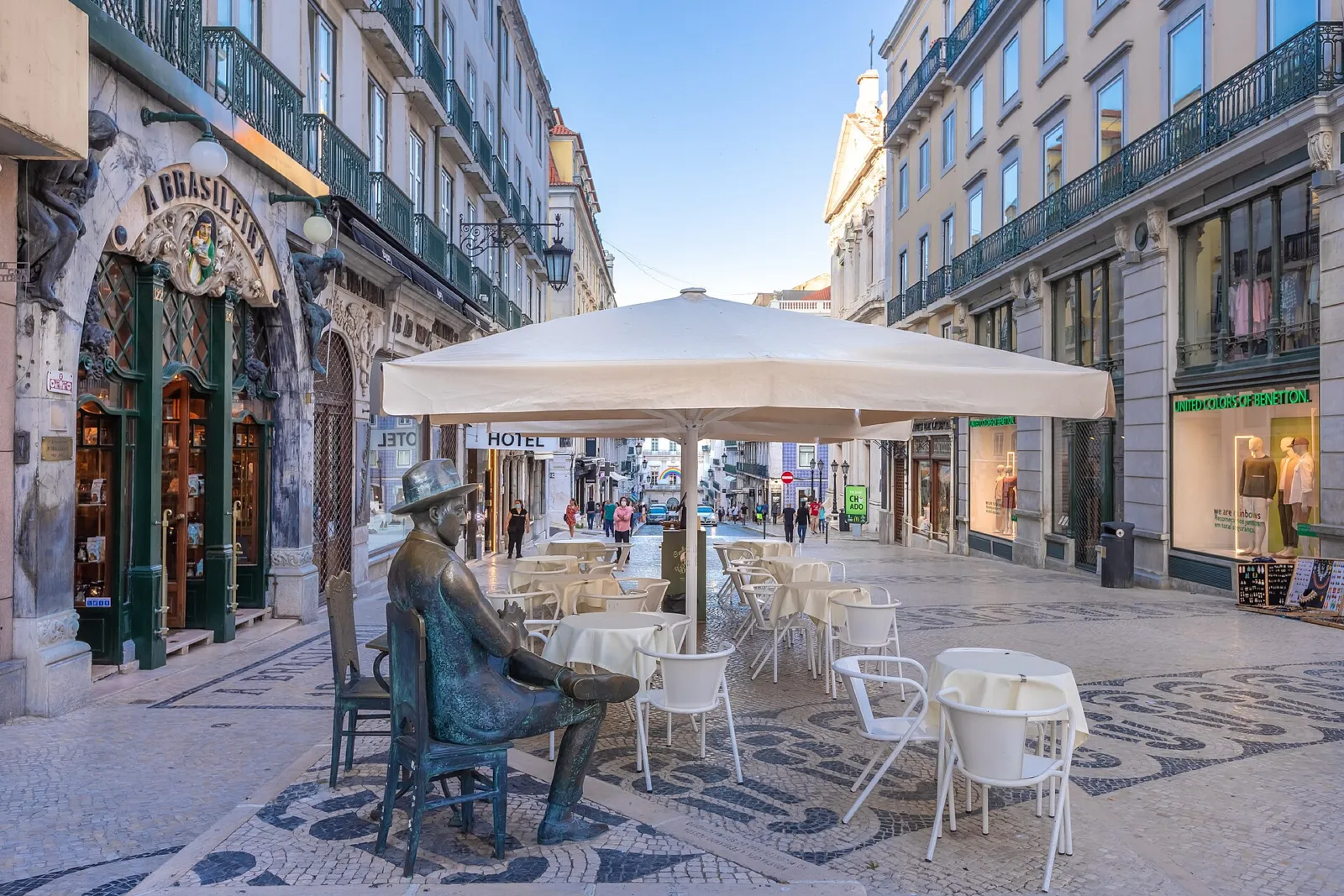 Estatua de Fernando Pessoa sentado junto a la terraza del café A Brasileira en el Chiado