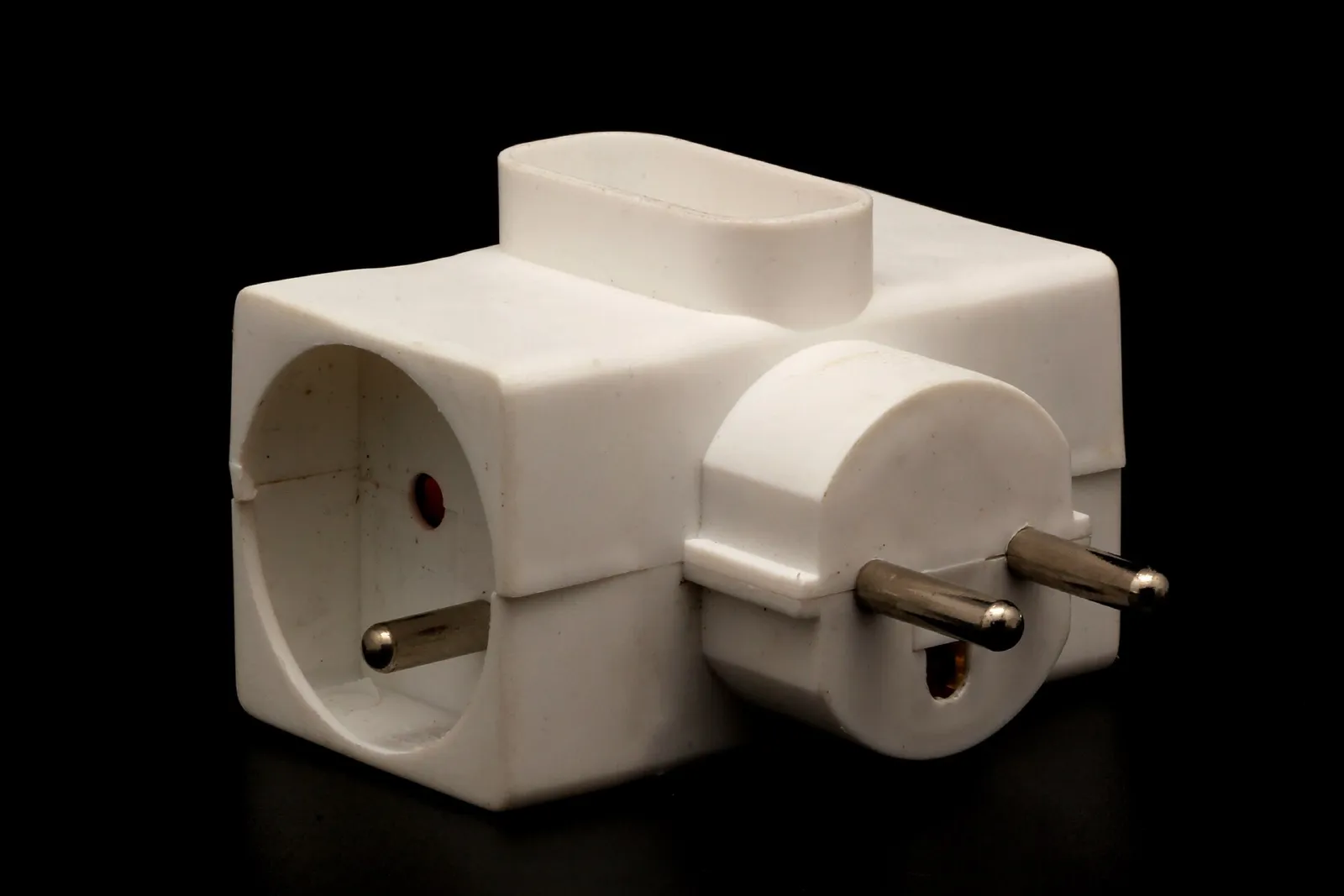 Adaptador eléctrico múltiple blanco con enchufes europeos de tipo F y tipo C sobre fondo negro