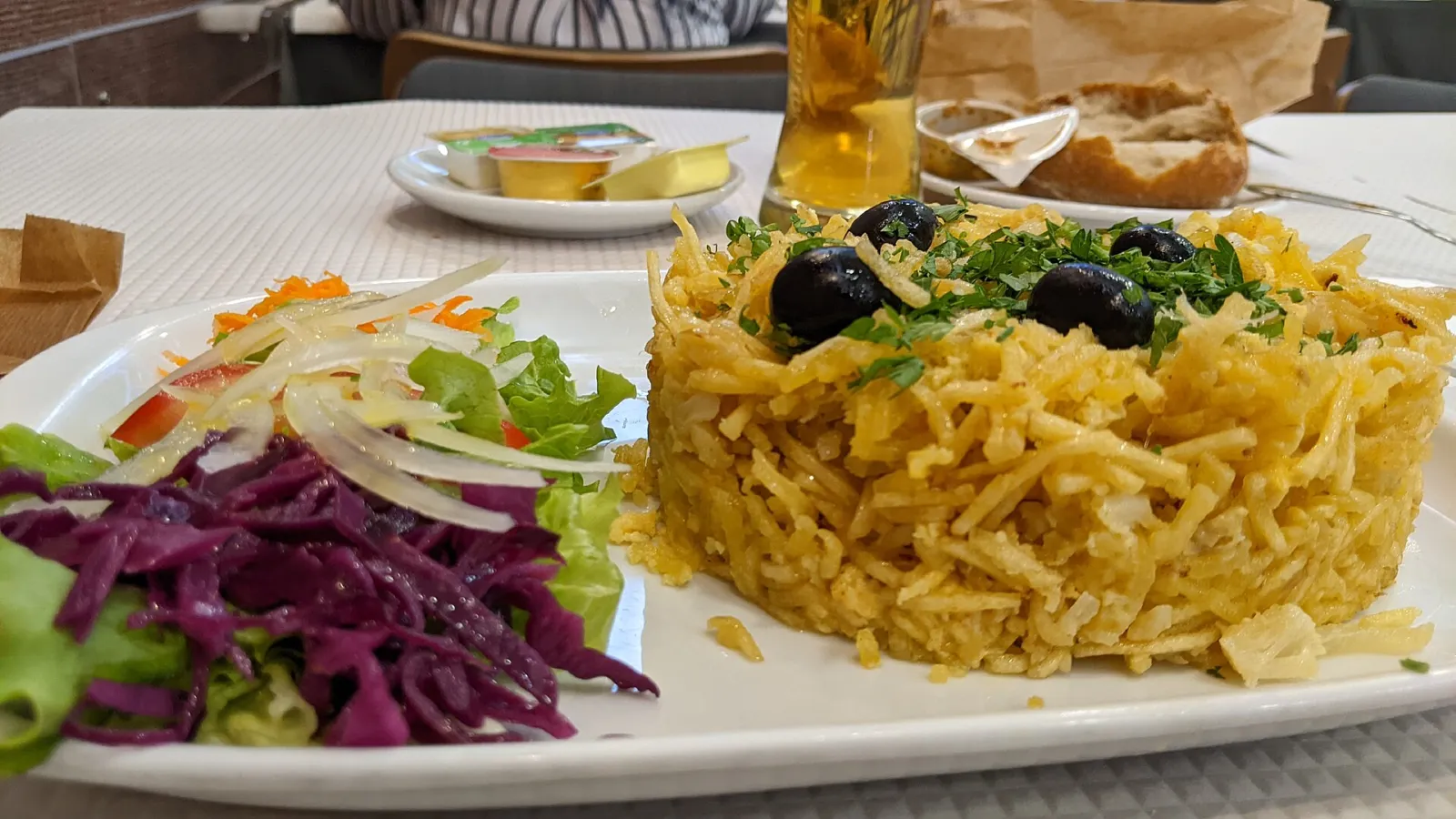 Plato de bacalhau à Brás, bacalao desmigado con patata, huevo y aceitunas negras en un restaurante de Lisboa