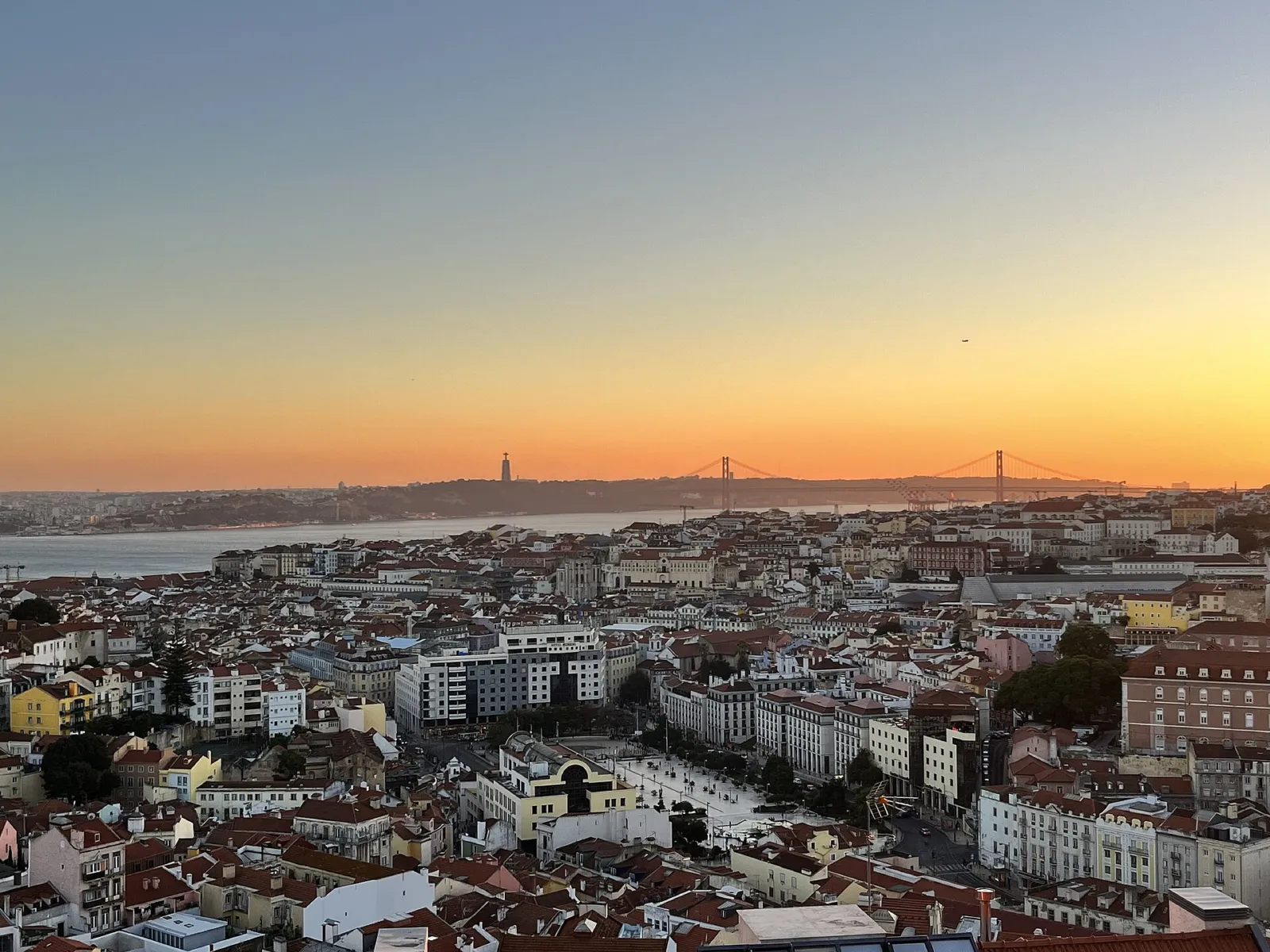 Atardecer dorado sobre los tejados de Lisboa visto desde el Miradouro da Graça