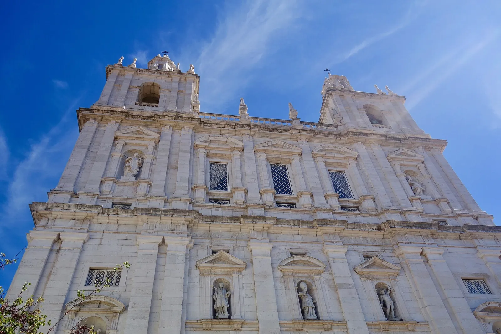 Fachada blanca de la iglesia del monasterio de São Vicente de Fora bajo un cielo azul