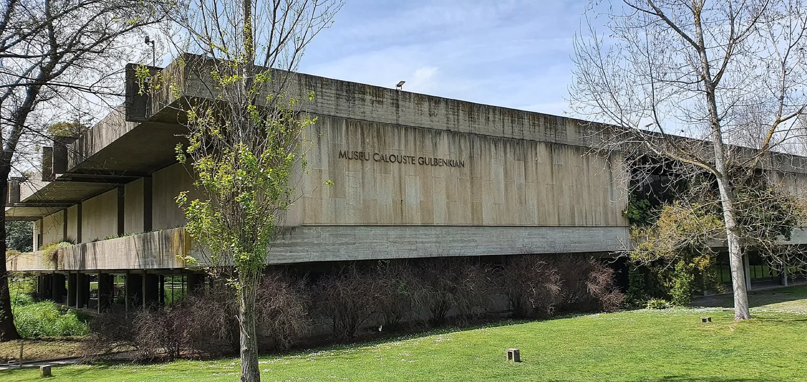 Edificio modernista del Museo Calouste Gulbenkian rodeado de árboles y césped en Lisboa
