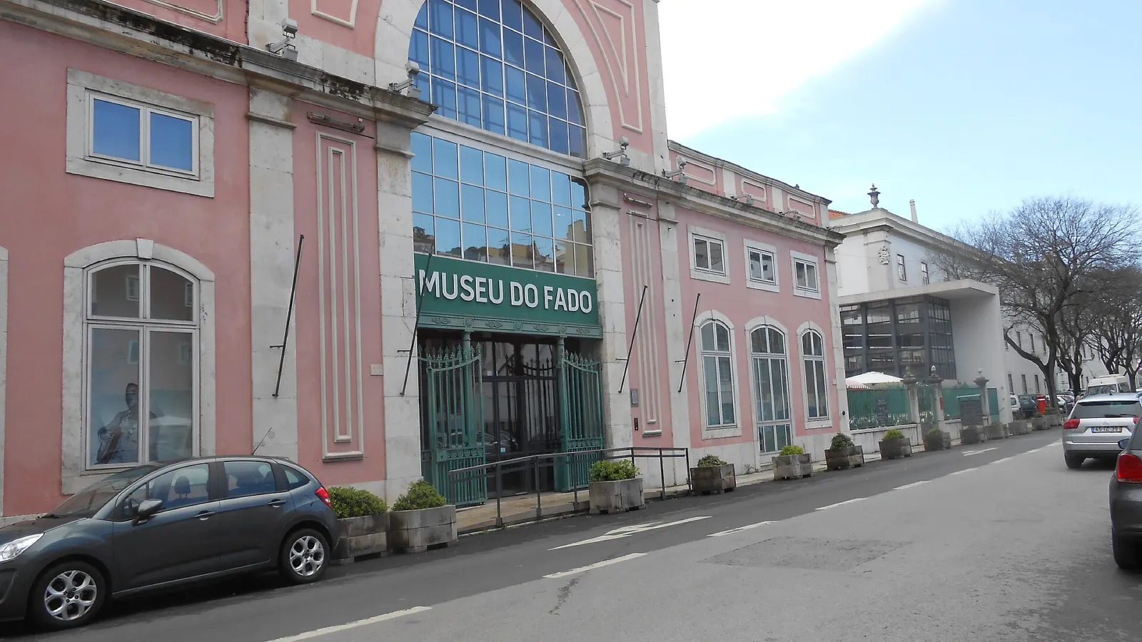 Edificio rosado del Museu do Fado en Alfama con su entrada acristalada
