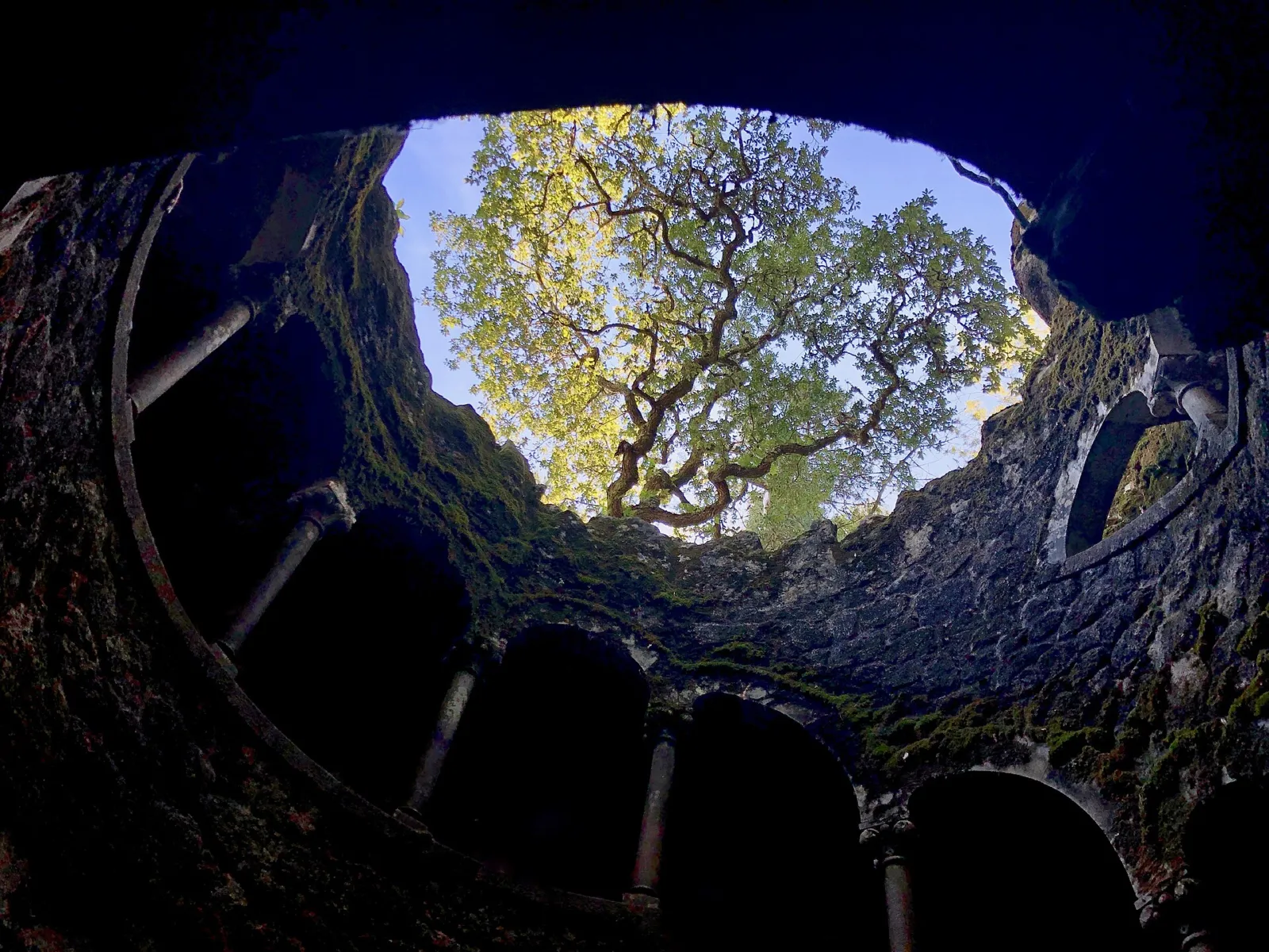 Pozo iniciático de la Quinta da Regaleira en Sintra visto desde abajo hacia la luz del cielo