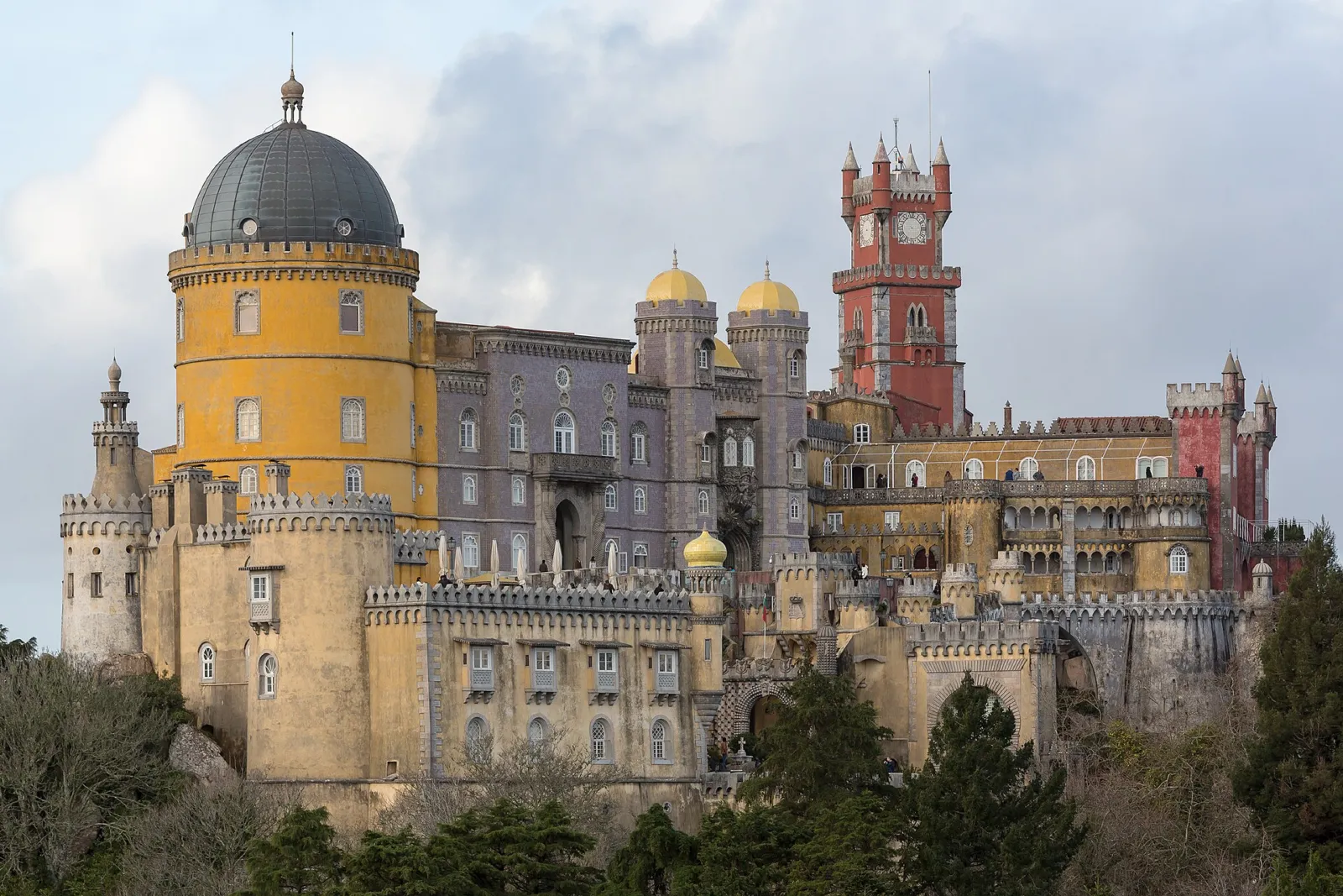 Palacio da Pena de Sintra con sus torres amarillas y rojas sobre la colina boscosa