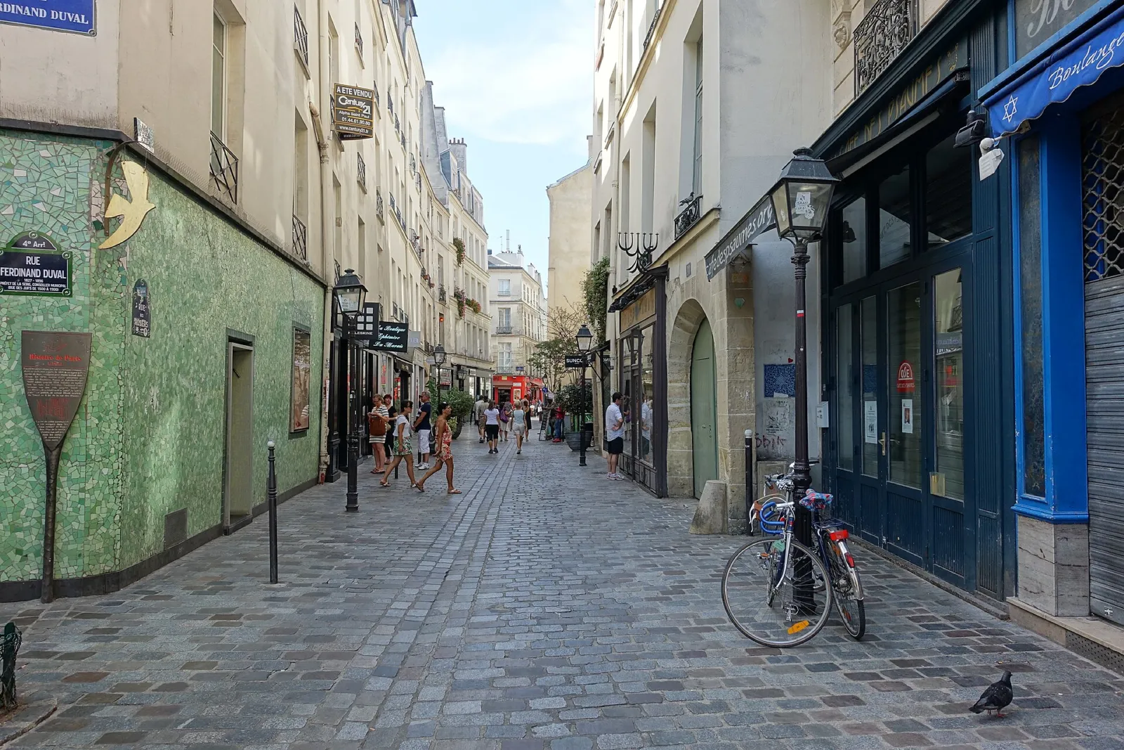 La estrecha y adoquinada rue des Rosiers, en el barrio judío del Marais, con comercios y viandantes