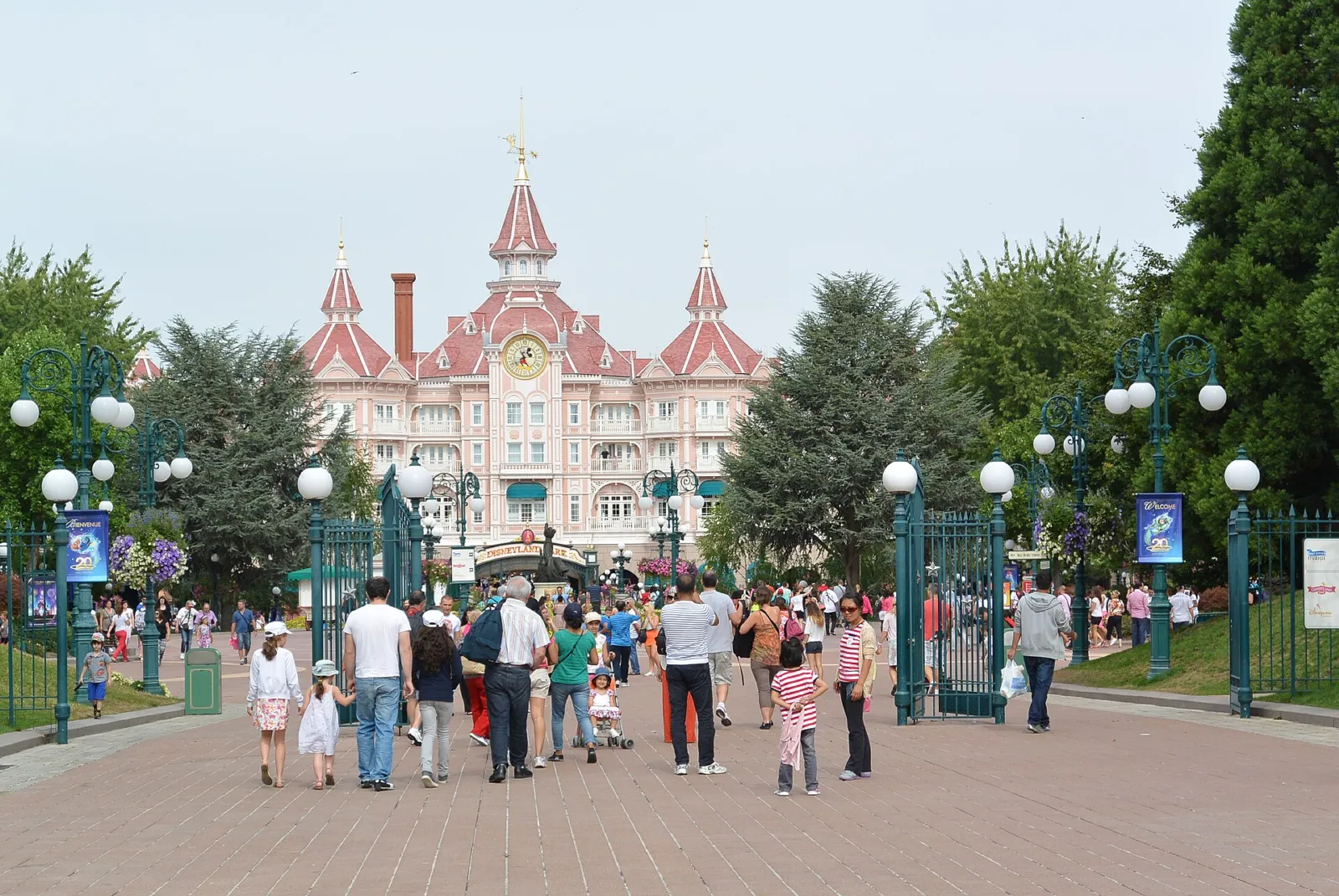 Entrada de Disneyland Park con el edificio rosa de Main Street al fondo y visitantes paseando