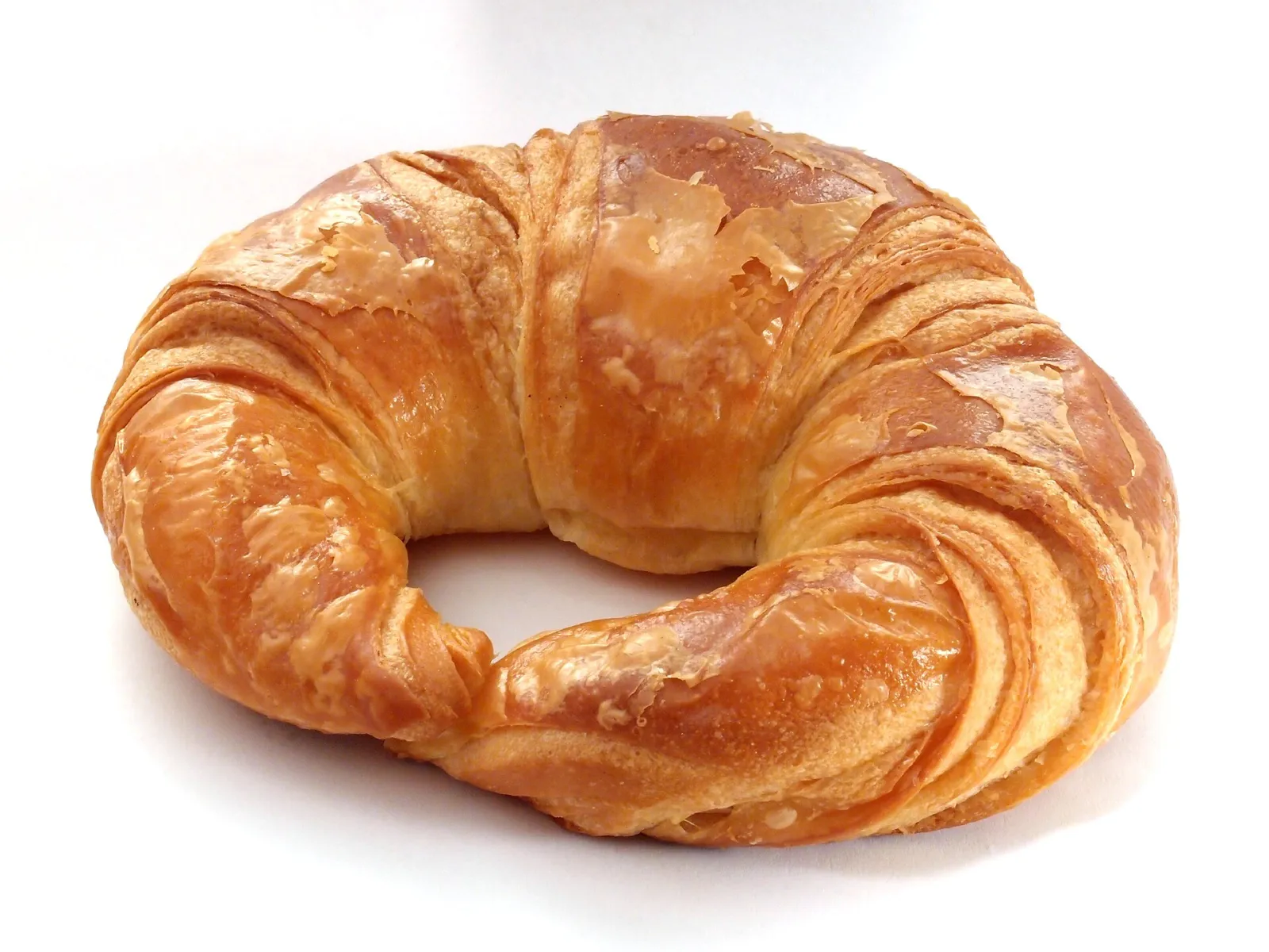 Un croissant recién hecho, clásico del desayuno parisino, sobre fondo claro